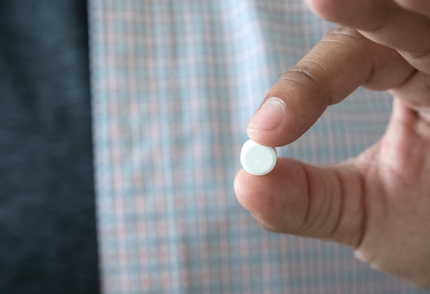 Medicine and health care concept man pours the pills out of the bottle holding medicine