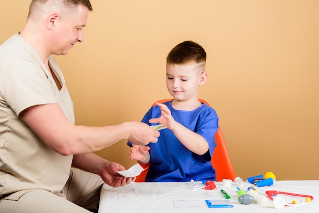 Medicine and health happy child with father with stethoscope small boy with dad in hospital father and son in uniform family doctor trust and values cool father play with kid father doctor