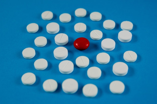 Medicine and health pills on blue background side view