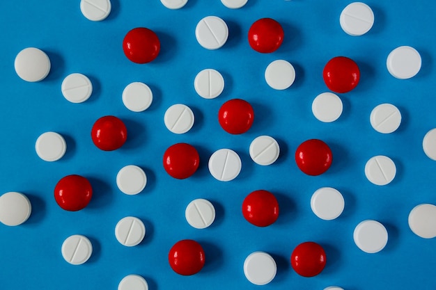 Медицина и здоровье, белые и красные таблетки на синем, вид сверху