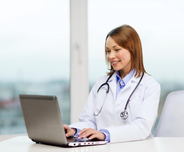 medicine and healthcare concept - busy doctor with laptop computer