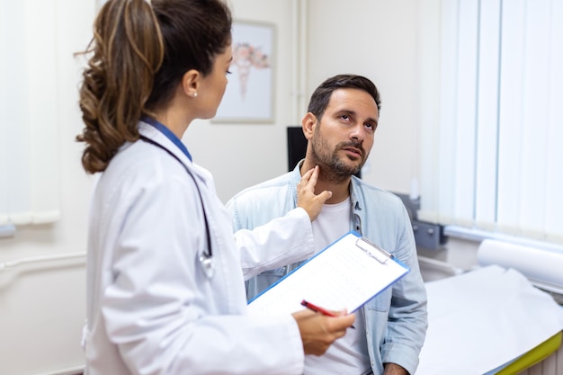 Medicine healthcare and medical exam concept doctor or nurse checking patient's tonsils at hospital Endocrinologist examining throat of young man in clinic