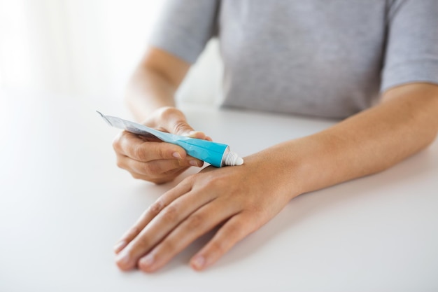 Photo medicine healthcare and people concept close up of woman hands applying cream or therapeutic salve