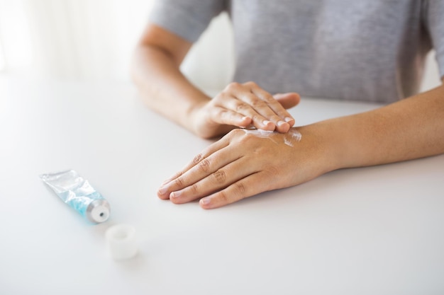 Photo medicine healthcare and people concept close up of woman hands applying cream or therapeutic salve