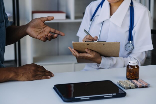 Medicine healthcare and people concept female doctor with tablet pc computer talking to smiling woman patient at hospital