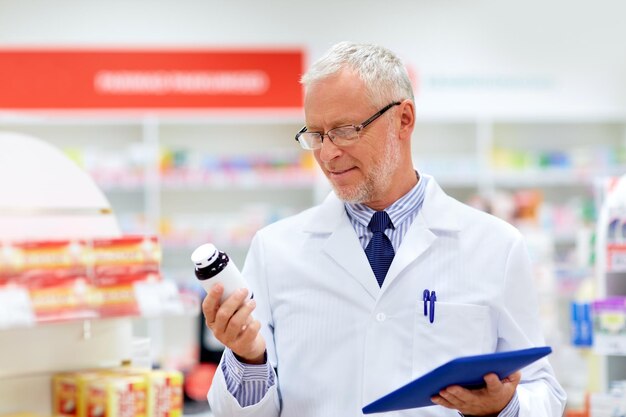 medicine healthcare and technology concept senior apothecary with tablet pc computer at pharmacy