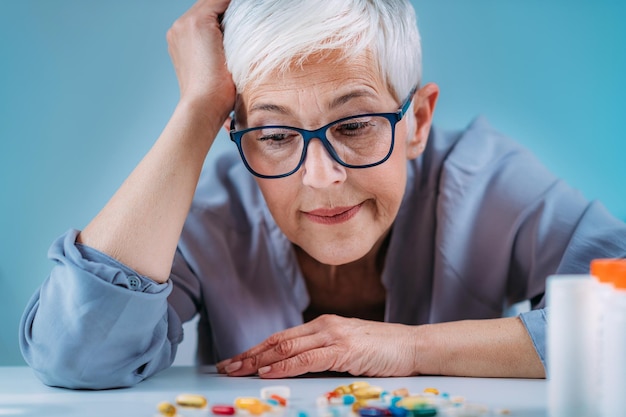 Foto medicine niet-aanhanging oudere vrouw op zoek naar pillen niet zeker of ze het medicijn had genomen of niet