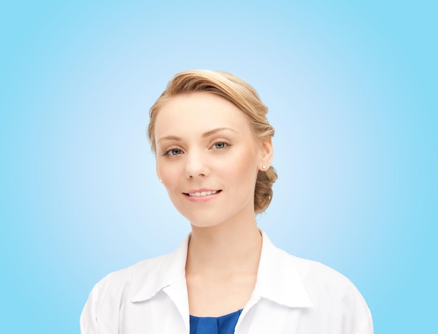 사진 의학, 사람, 직업 및 의료 개념 - 파란색 배경 위에 흰색 코트를 입고 웃고 있는 젊은 여성 의사