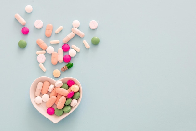 Medicine pills and capsules on pastel blue background health\
pharmacy concept