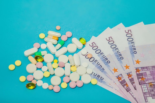 Таблетки от коронавируса на банкнотах евро на синем фоне