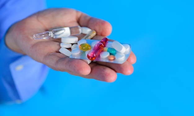 Medicine pills in hand tablets in hand of patient medical
concept hand of man holds different pills