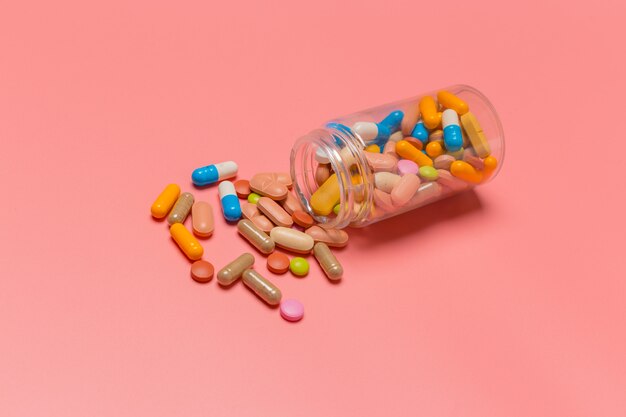 Medicine pills on pink background. Top view