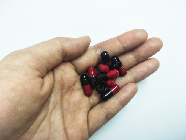 medicine pills, tablets and capsules in hand women on white background 