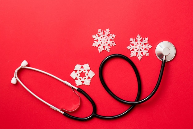 medicine red background with stethoscope and snowflakes, medical winter