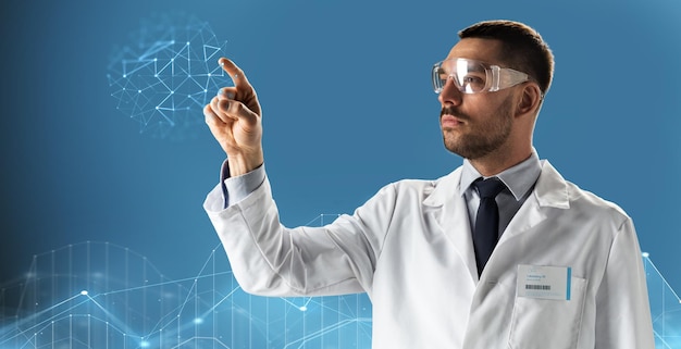 medicine, science, healthcare and people concept - male doctor or scientist in white coat and safety glasses pointing finger to low poly projection over black background