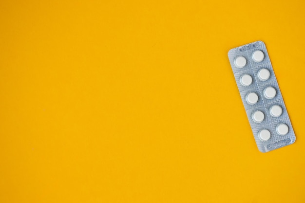 Medicine shipping pills in a package on a yellow background with copy space