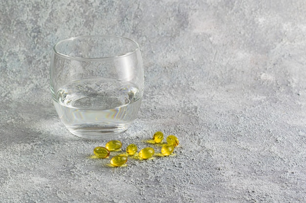 Photo medicine tablets and glass of water on grey background. medicine concept of respiratory disease treatment. disease spread prevention