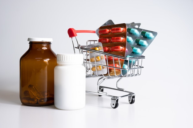 Лекарства, витамины и антиоксидантные добавки в тележке или корзине