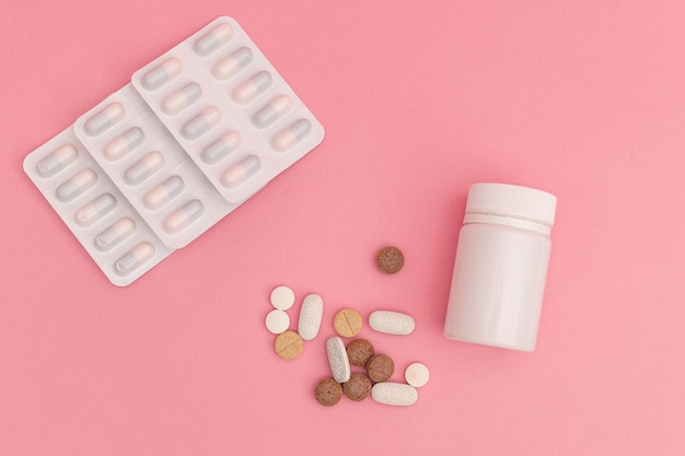 Medicine with pills on pink background