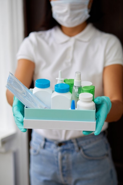 Medicine woman courier in mask and gloves with medical pills purchases during the prevention of coronovirus, Safety home and quarantine concept, Volunteer with Donation goods.