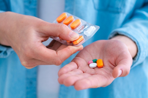 Medicine woman taking pills and vitamins for wellness at home.