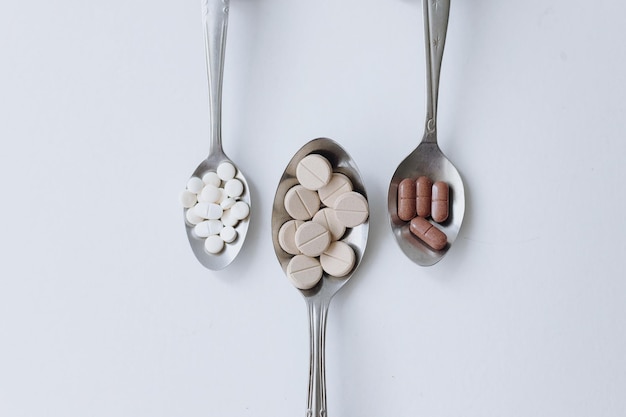 Medicines in different spoons Minimalist and creative concept for healthcare