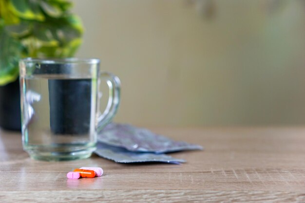 medicines and a glass of water on the table for health concepts