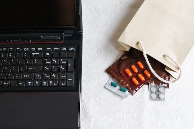 Medicines and pills next to laptop, notebook keyboard. Stress in the work
