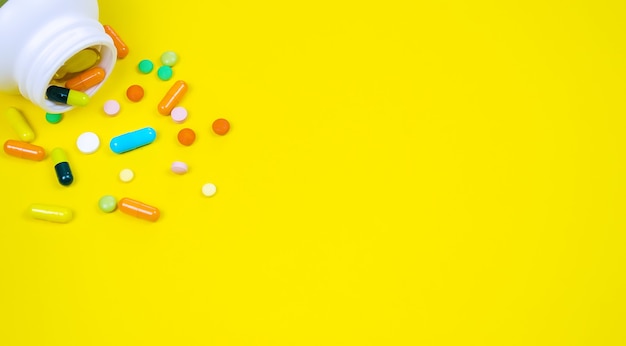 Medicines, pills, mask, virus, on a yellow background. Selective focus