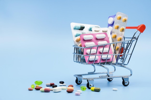 Medicines in shopping trolley with drug bottles with copy space