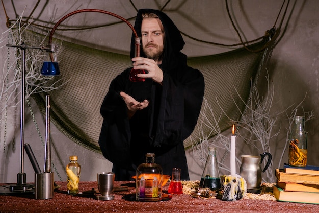 The medieval alchemist scientist conducts a ritual in his laboratory.