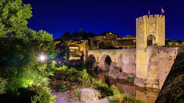 밤에 베살루의 고대 도시에서 강을 건너는 중세 다리 제로나 스페인
