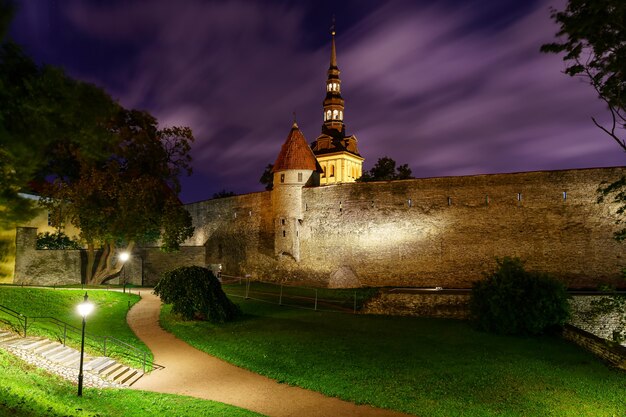 Medieval city wall of Tallinn Estonia at night with fleeing clouds.