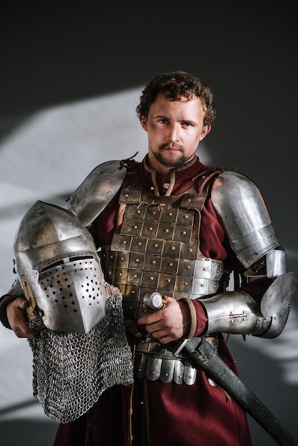 Cavaliere medievale in armatura e arma su sfondo scuro. ritratto del cavaliere