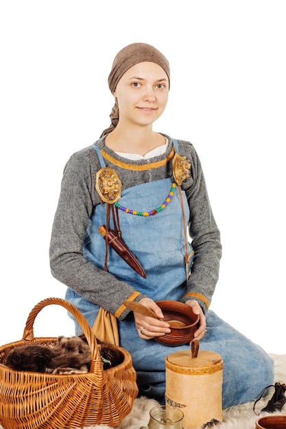 調理器具を保持している歴史的な衣装を着た中世のスラブの美しい女性