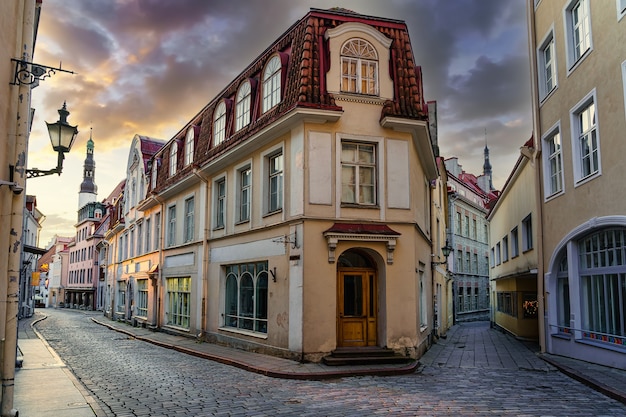 エストニアのタリン市の日没時の古い建物のある中世の通り。