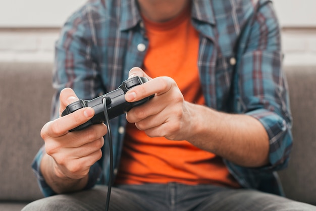 Medio sectie van een man die het videogame met joystick speelt