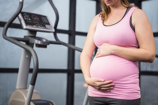 Medio sectie van zwangere vrouw wat betreft haar buik bij de gymnastiek