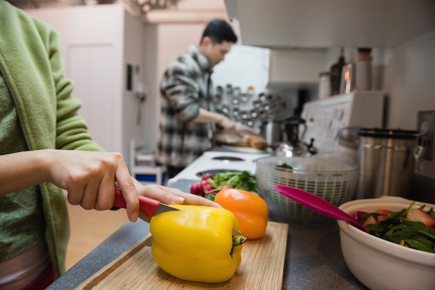 Medio sectie vrouwen scherpe groenten in keuken