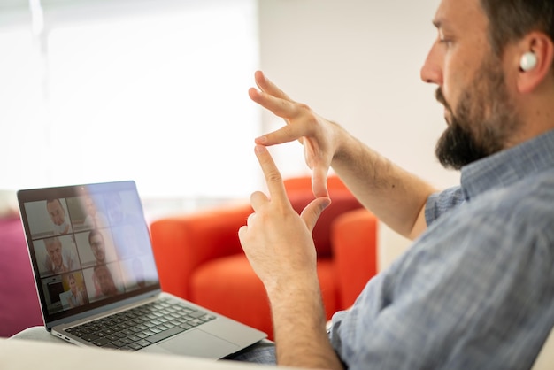 Medio volwassen man die online conferentie heeft en thuis werkt