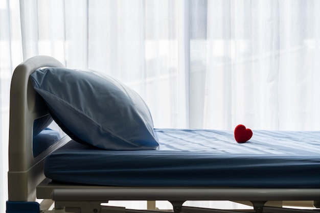 Medisch concept. een rood hart op het bed van de patiënt in het ziekenhuis gezondheidszorg.