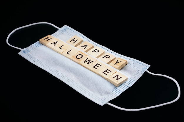 Medisch masker en houten woorden Happy Halloween op zwart