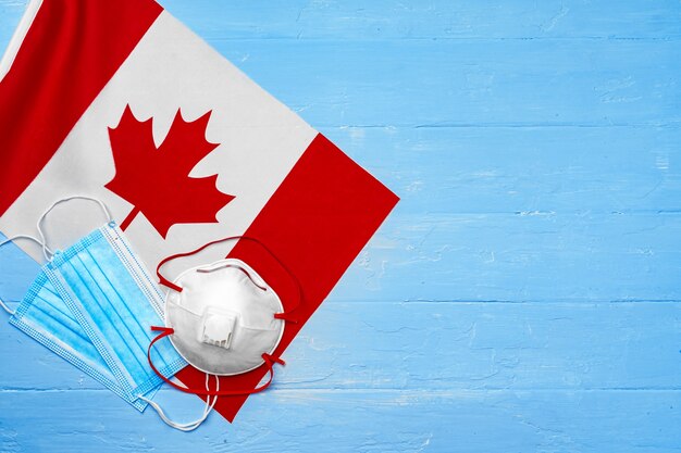 Medisch masker op vlag van Canada op houten bord close-up