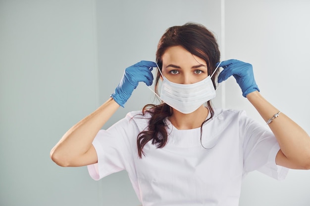 Medisch masker Portret van professionele vrouwelijke tandarts met apparatuur die binnenshuis staat