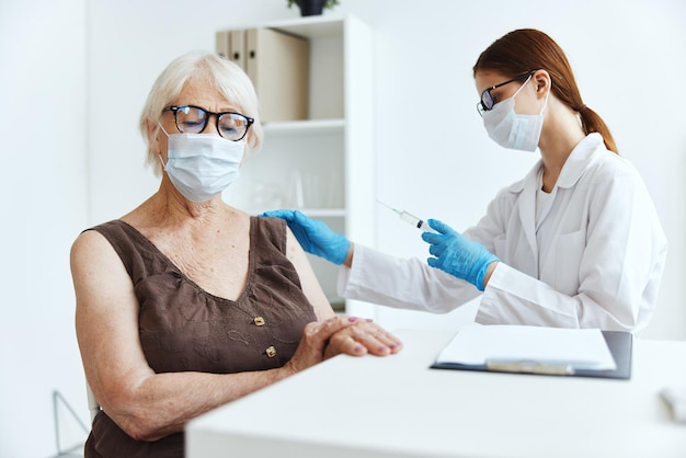 Medisch maskerverpleegkundige maakt een injectie in de arm immuniteitsbescherming covid-paspoort