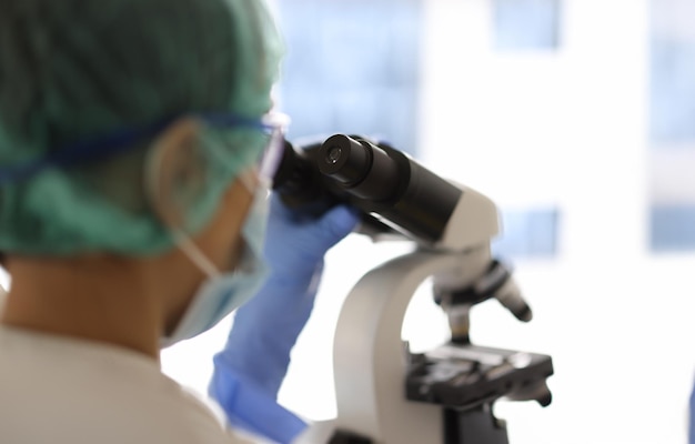Medisch onderzoeker kijkt door een microscoop
