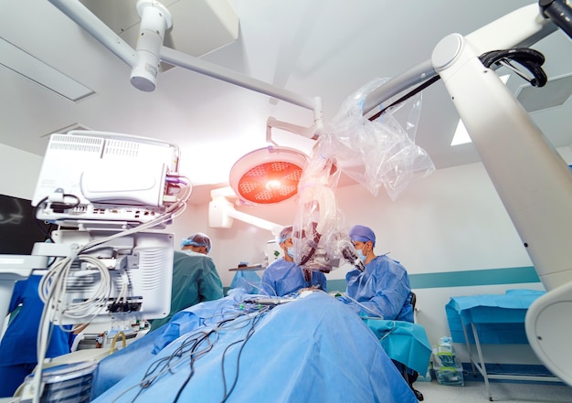 Medisch team dat een chirurgische ingreep uitvoert in een heldere, moderne operatiekamer Medische hulpmiddelen voor neurochirurgie Moderne apparatuur in de operatiekamer