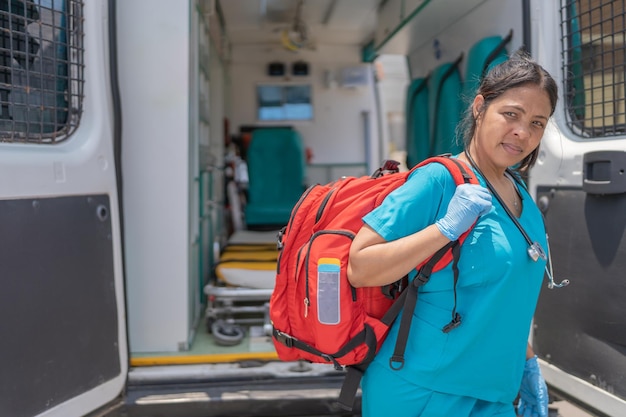 Medisch technicus met een EHBO-tas die buiten naast een ambulance staat