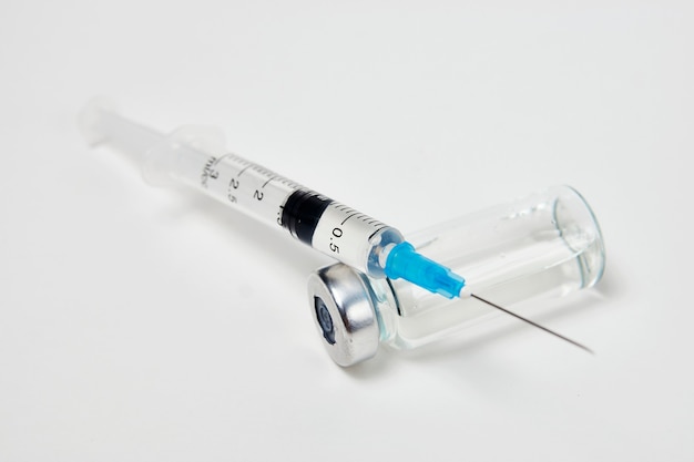 Medisch vaccinatieconcept met spuit en medische ampullen. Vaccin fles en spuit injectie op witte achtergrond met kopie ruimte, close-up