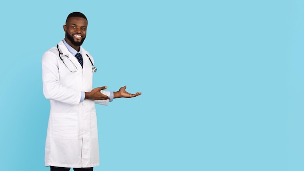 Medische advertentie Glimlachende zwarte mannelijke arts die opzij wijst naar kopieerruimte